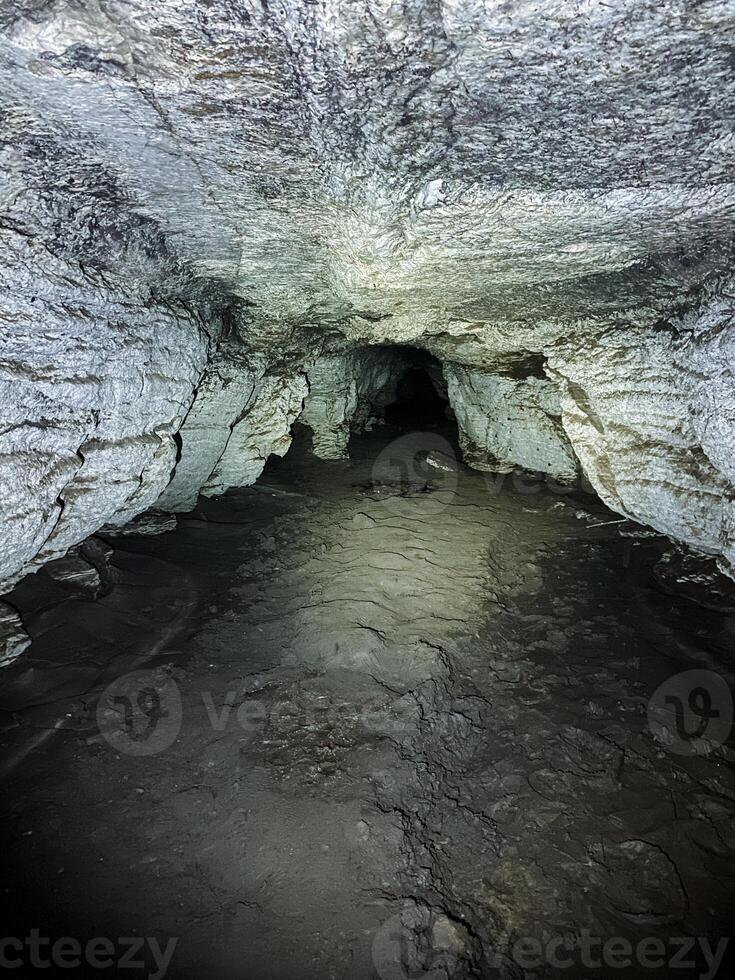 A cave with a small opening in the middle photo