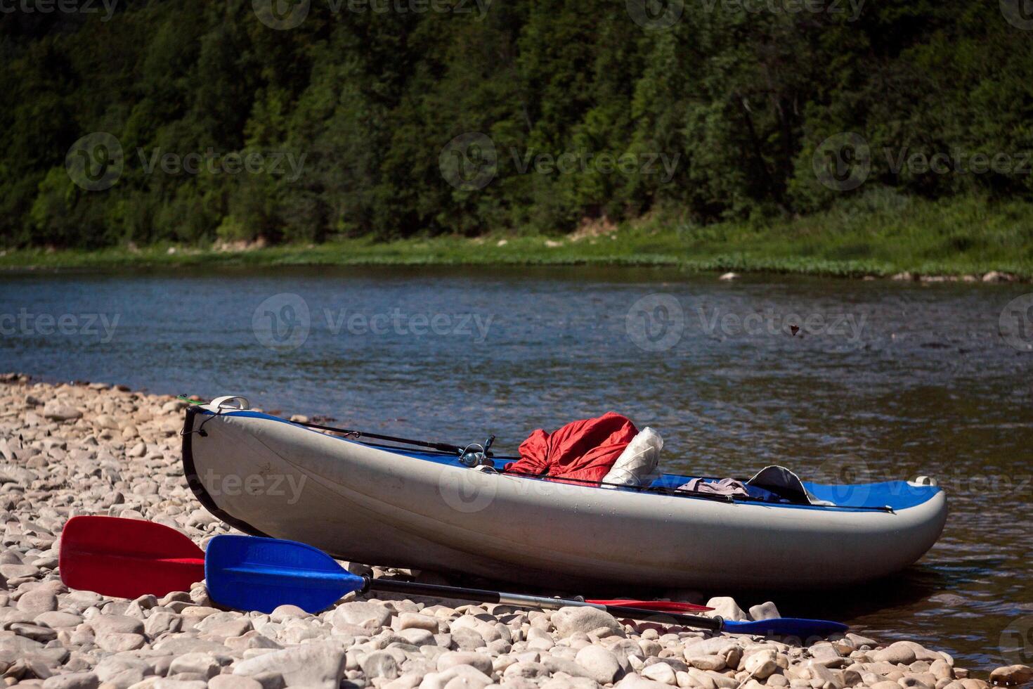 A canoe and a kayak on the shore of a river photo