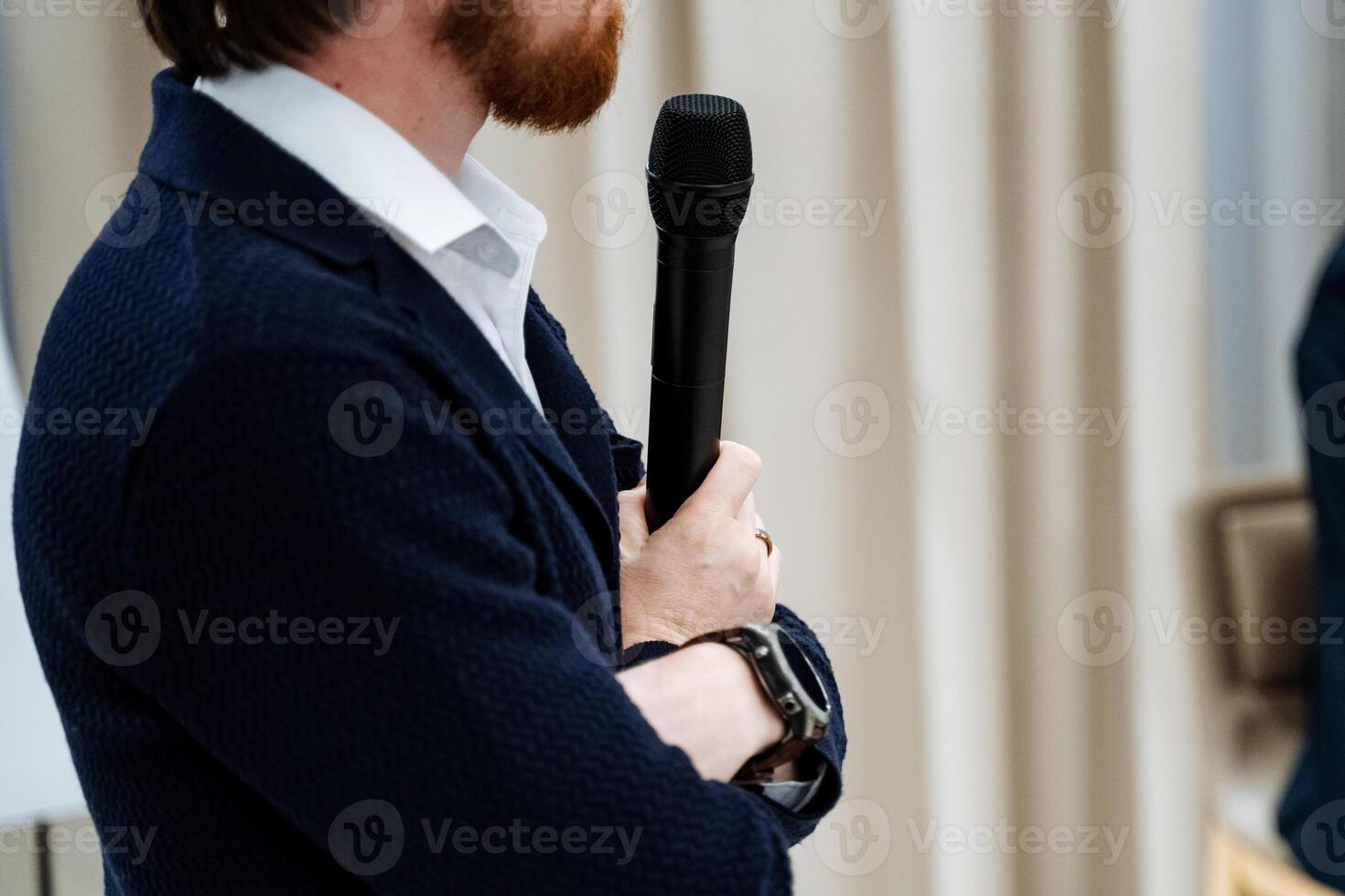 A man with a beard holding a microphone photo