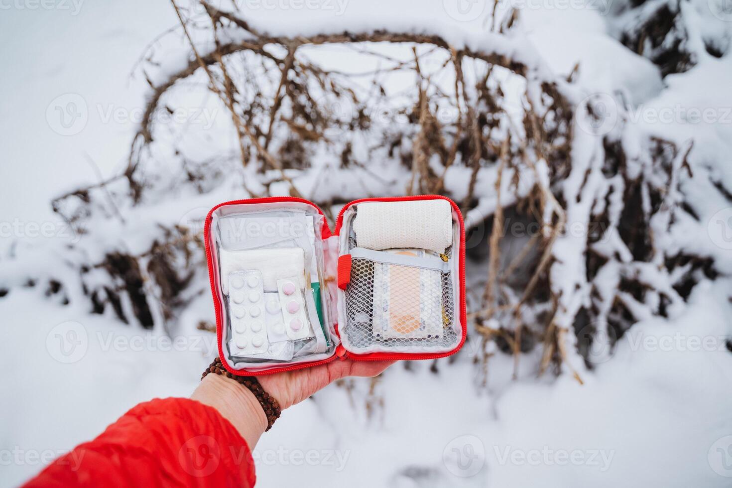 A person holding a small red case with a small red bag photo