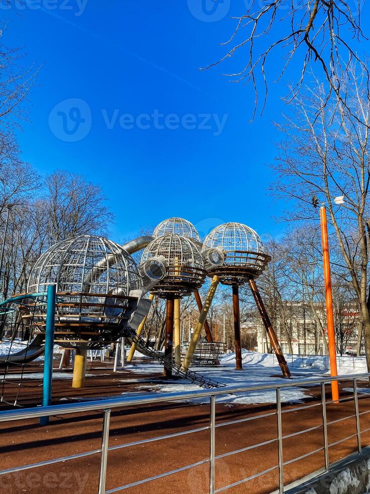 A playground with a large metal structure in the middle photo