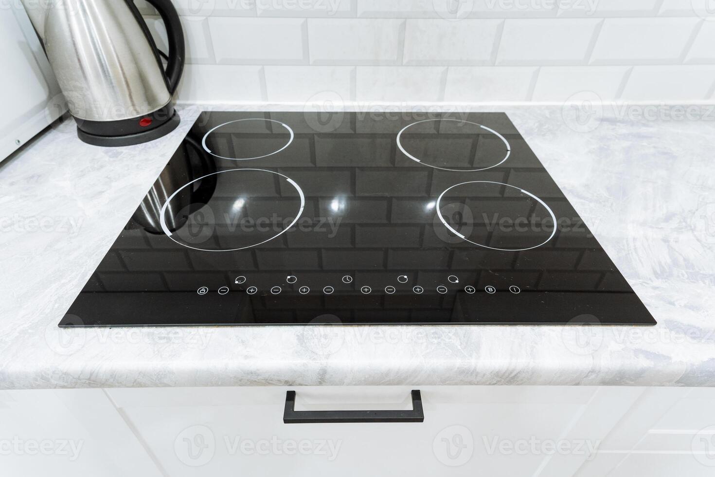 A black stove top on a white counter top photo
