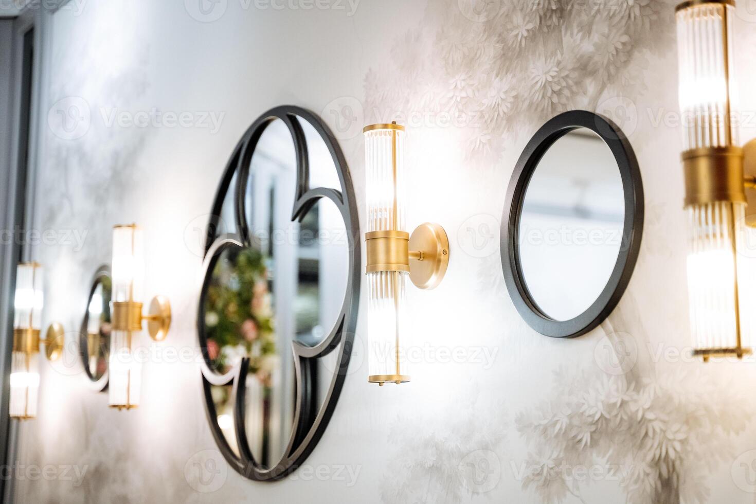 A wall with a mirror and several round mirrors photo