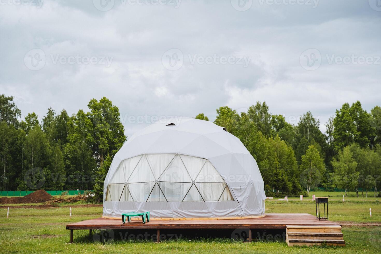 A dome tent sitting on top of a wooden platform photo