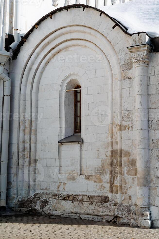 A man is sitting on a bench outside of a building photo