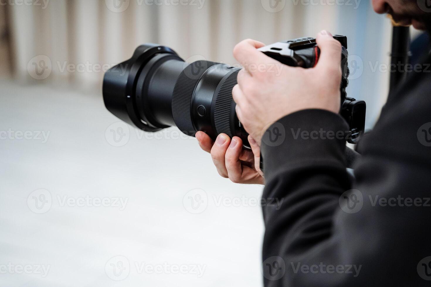 A man holding a camera with a lens photo