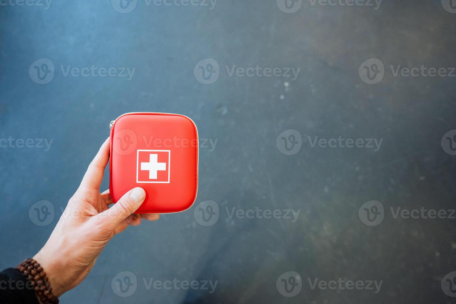 A person holding a red first aid kit photo