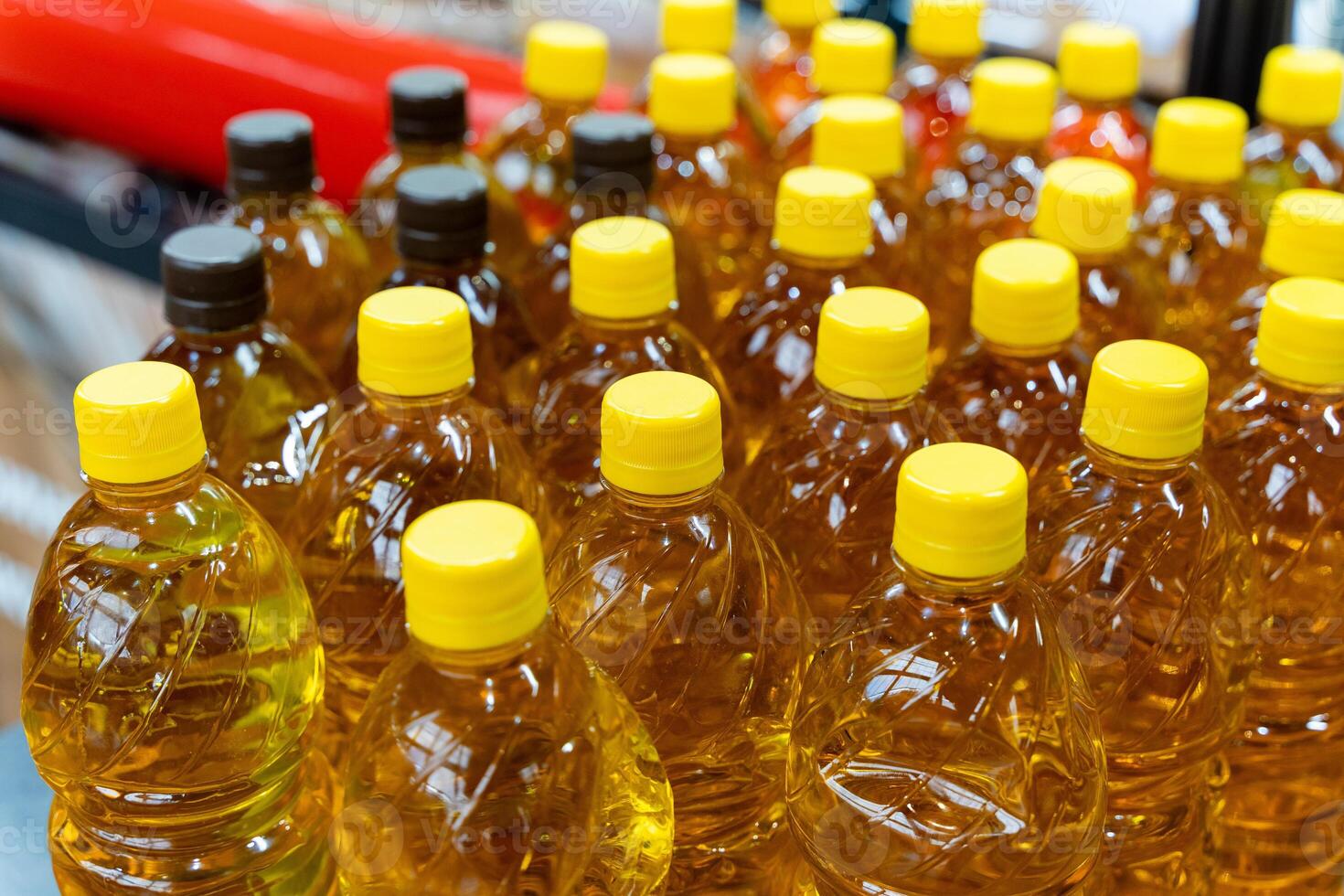 Many bottles of oil are lined up on a shelf photo