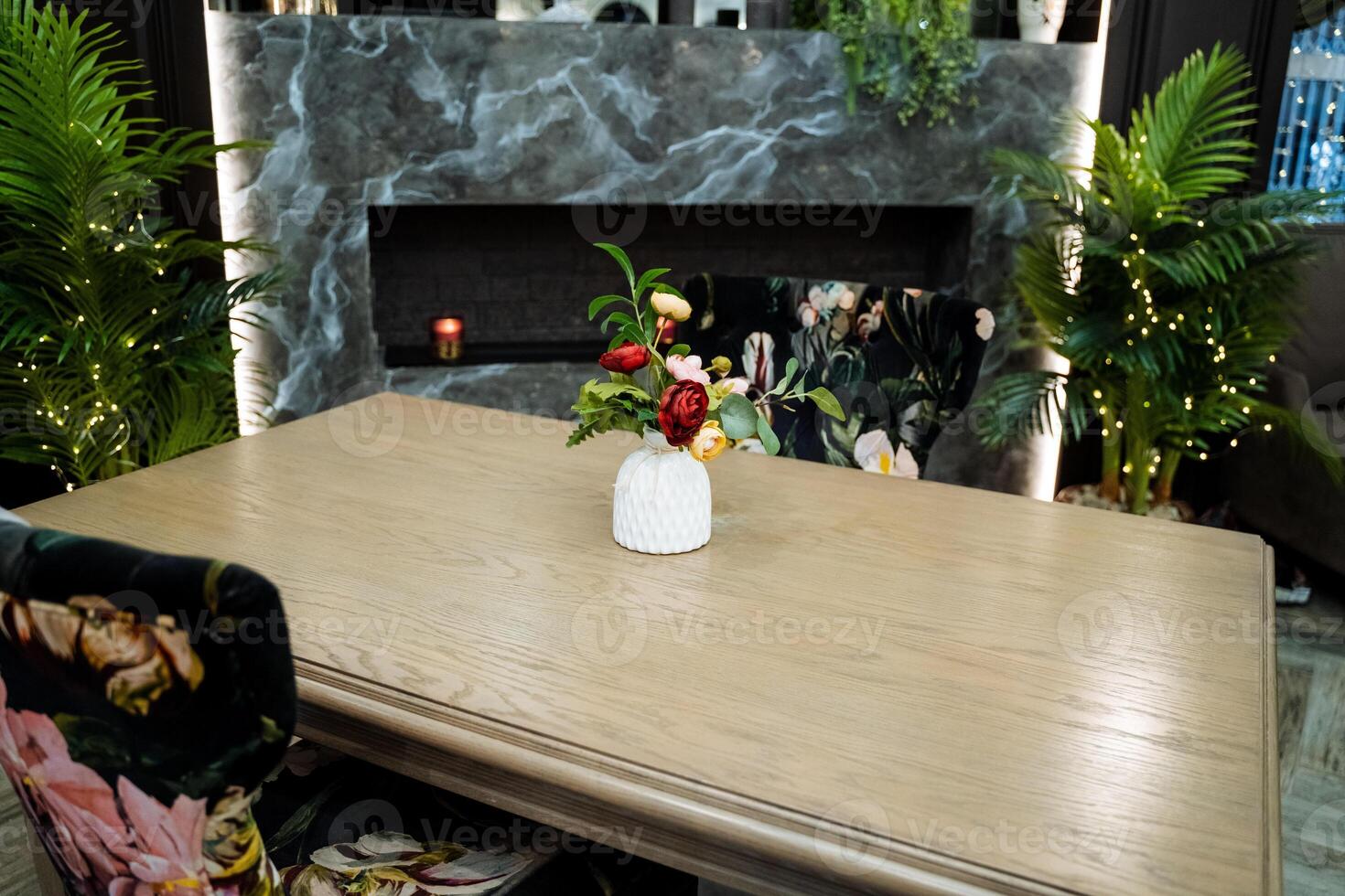 A table with flowers and a vase on it photo
