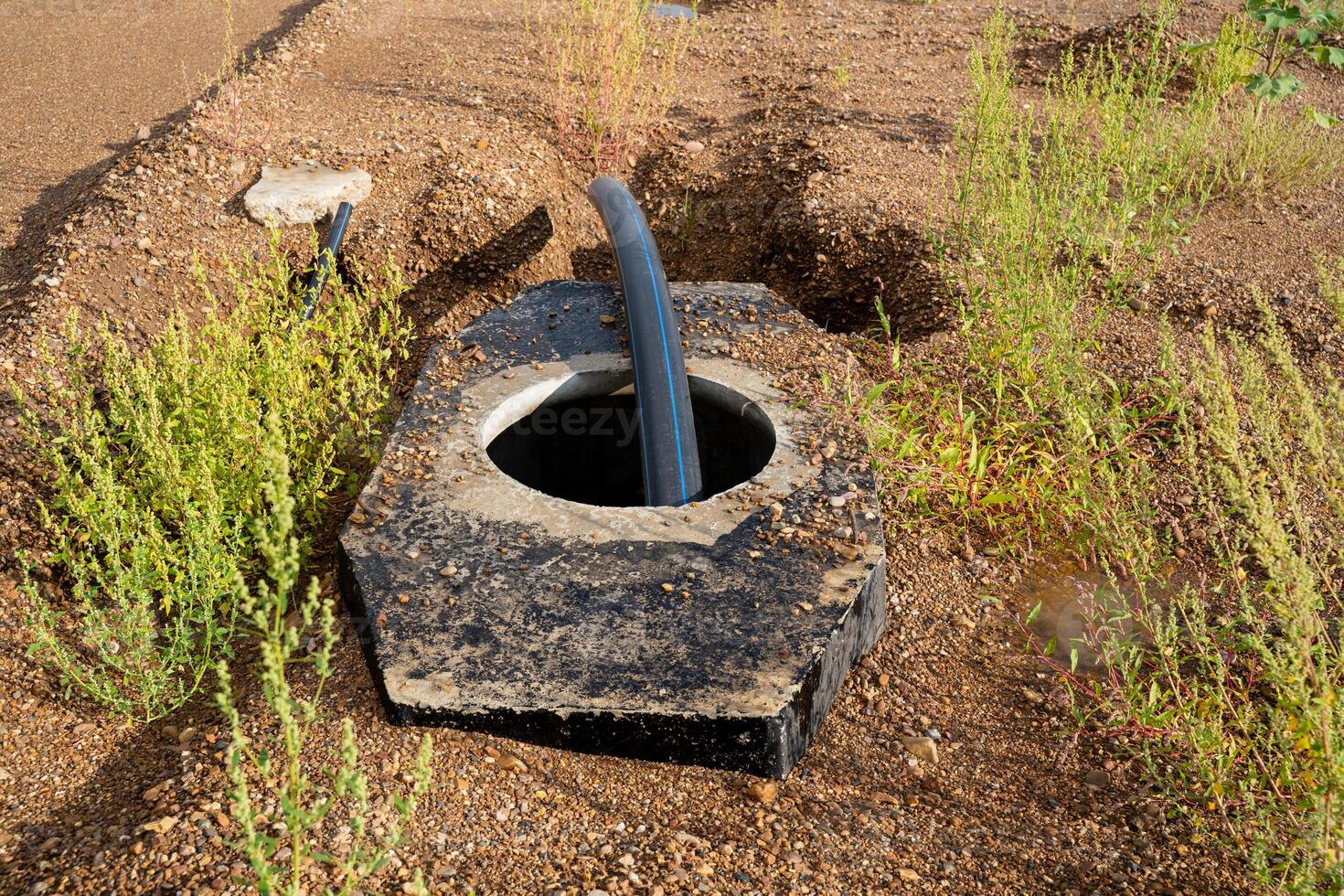 A concrete water pipe in the dirt photo