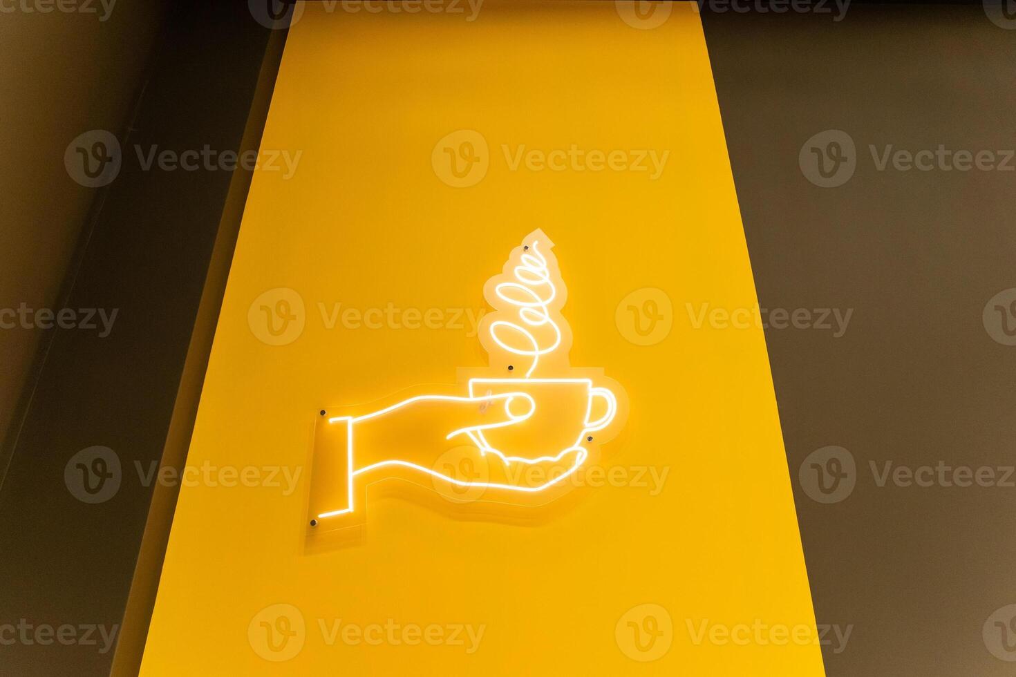 A neon sign that says coffee on a yellow wall photo