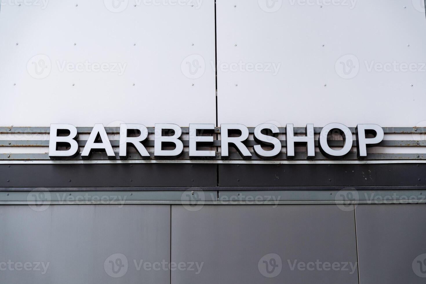 A sign that says barber shop on the side of a building photo