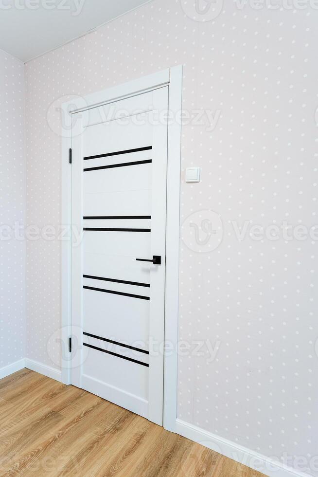 A white door in a room with a pink wall photo
