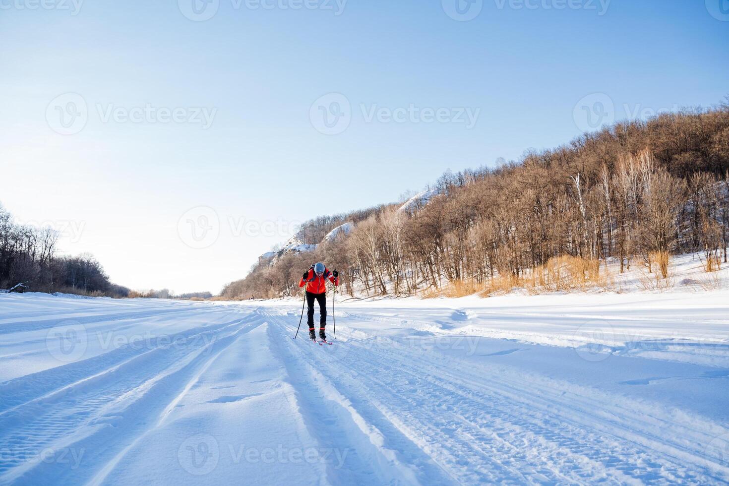A person cross country skiing on a snowy road photo