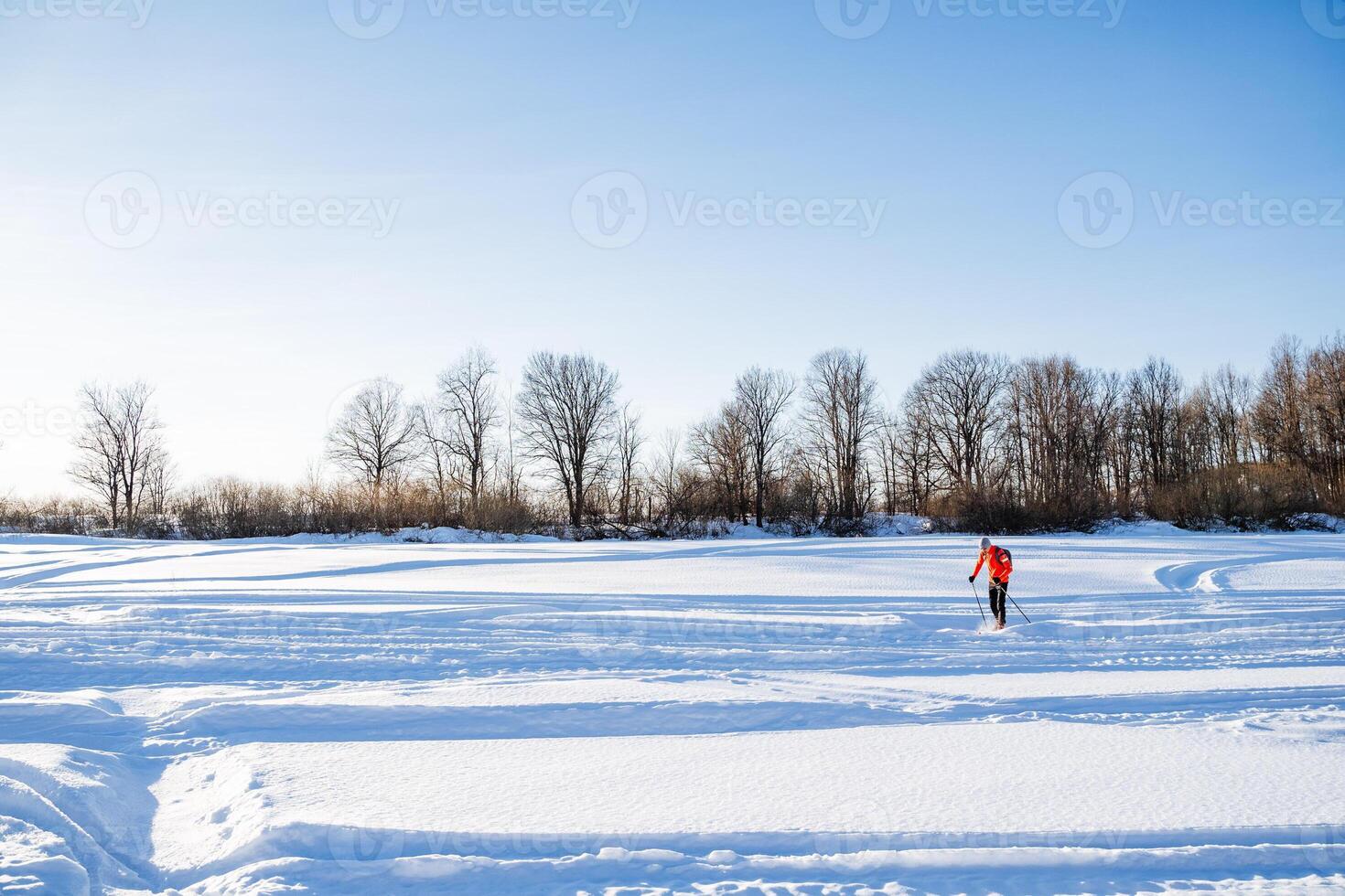 A person is skiing across a snow covered field photo