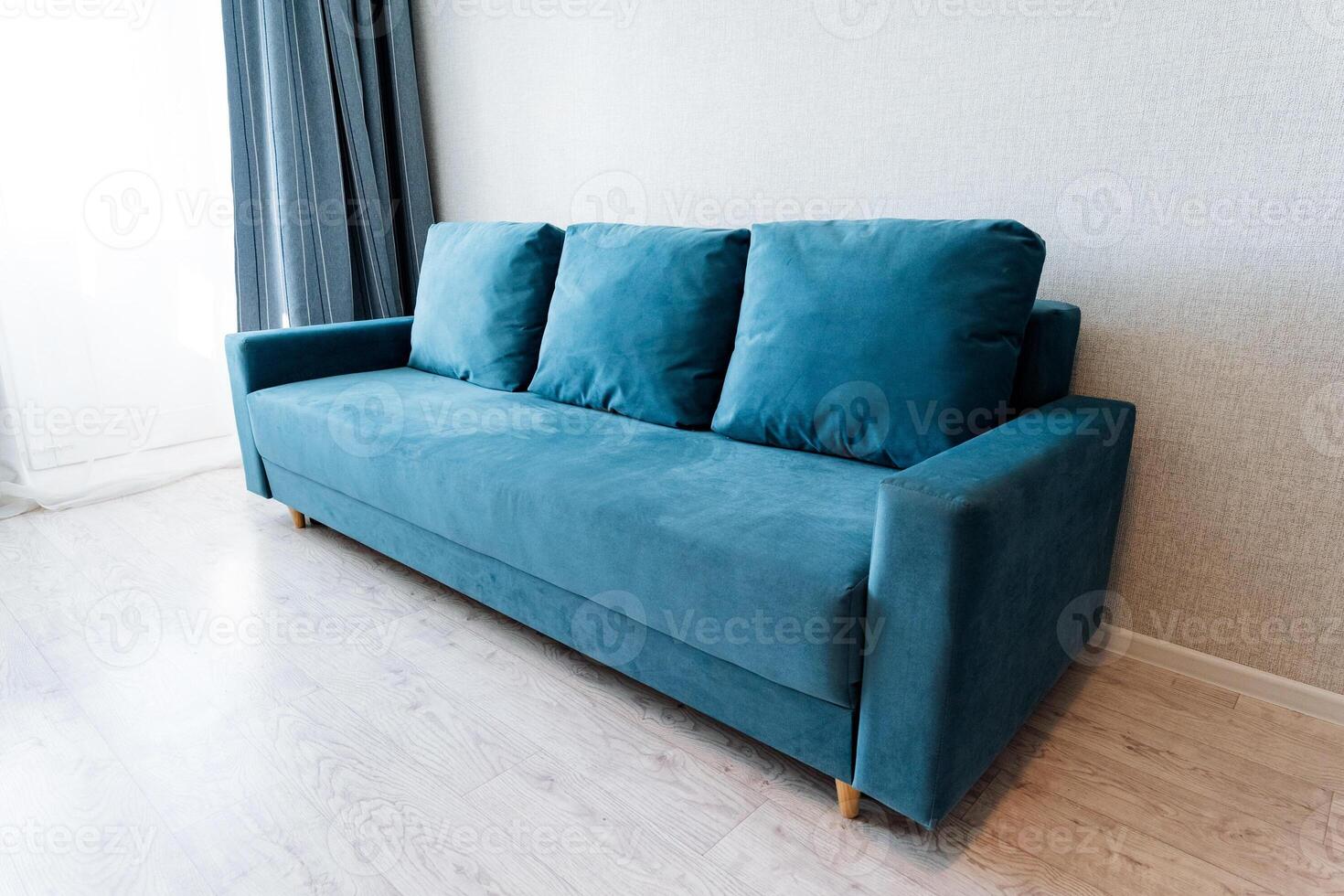 A blue couch in a room with a window photo