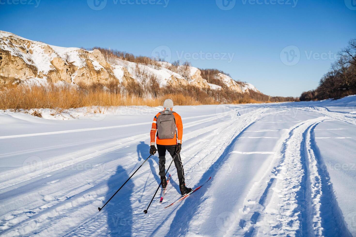 A person cross country skiing on a snowy trail photo