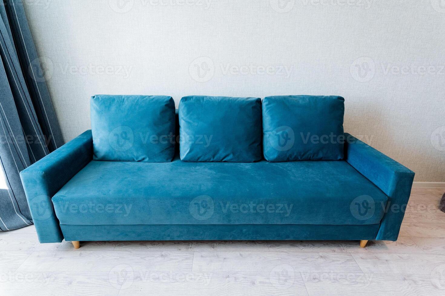 A blue couch in a room with a window photo
