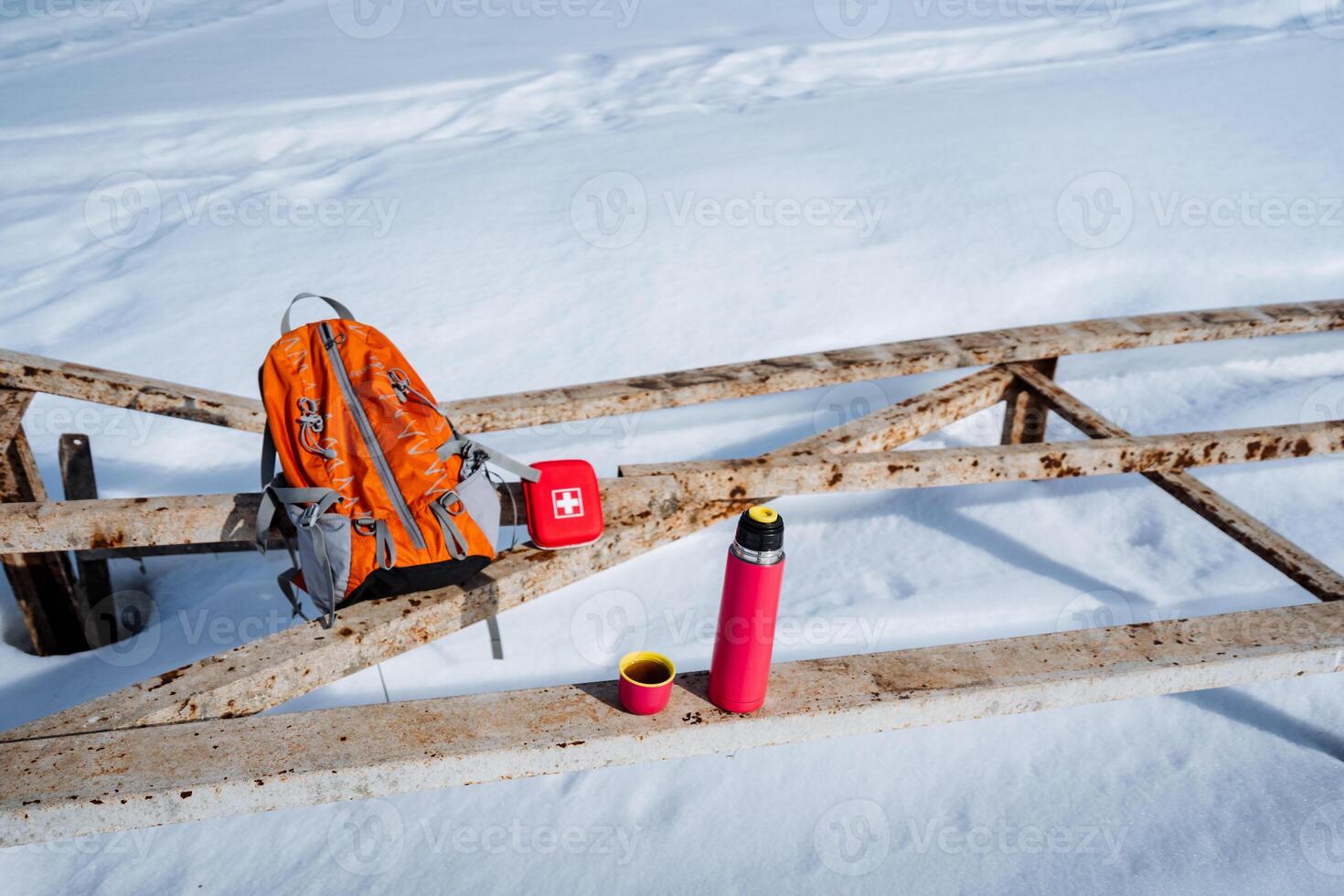 A backpack and a water bottle on a wooden bridge photo
