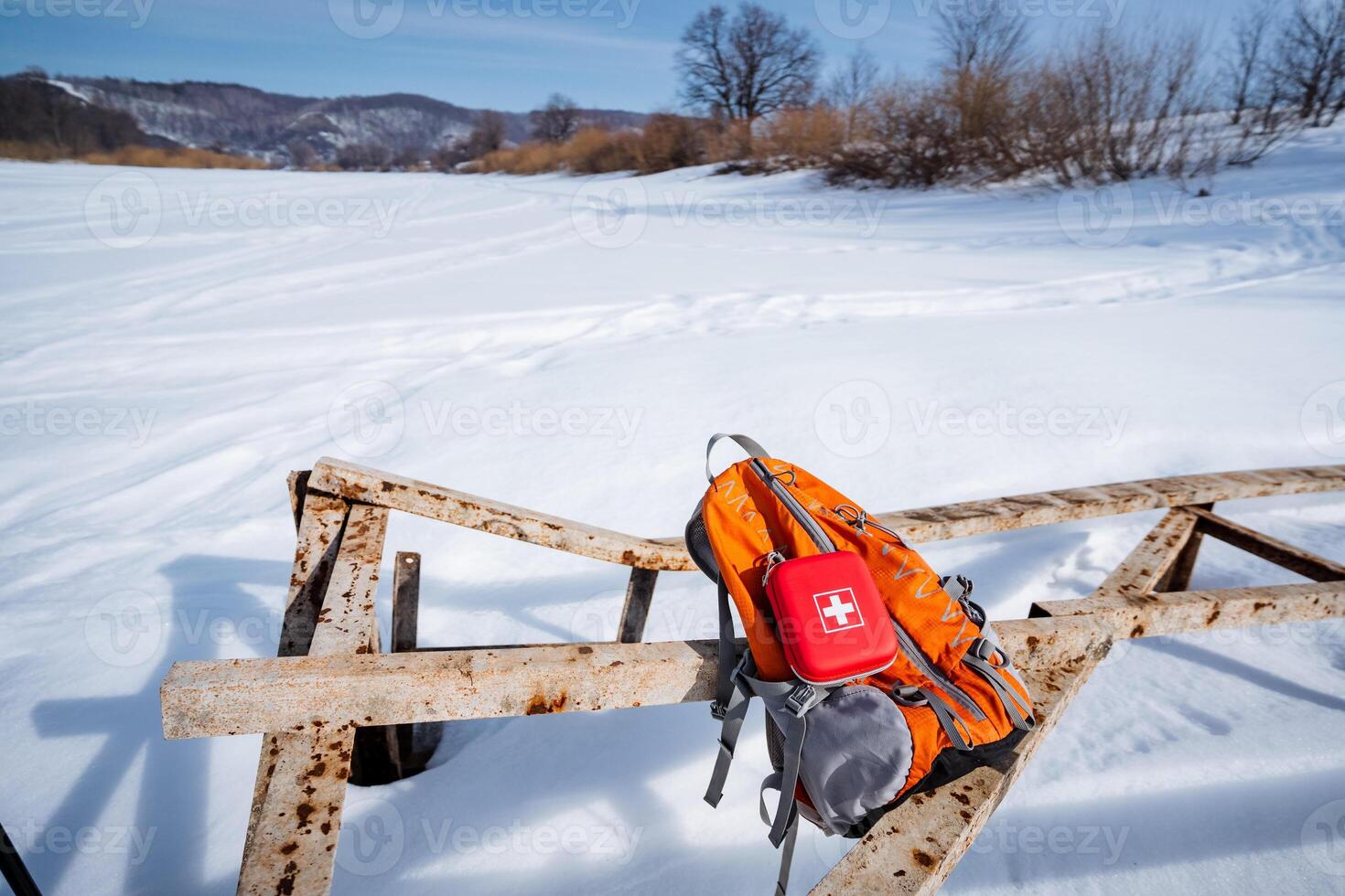 A backpack is sitting on top of a wooden bench photo
