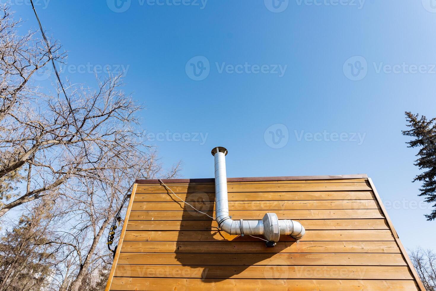 A small wooden house with a pipe sticking out of the side photo