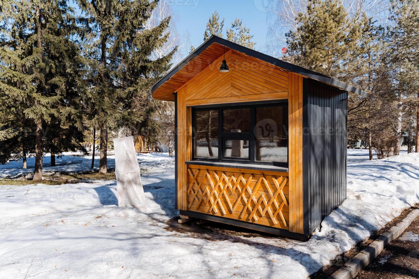 A small cabin in the snow with trees in the background photo