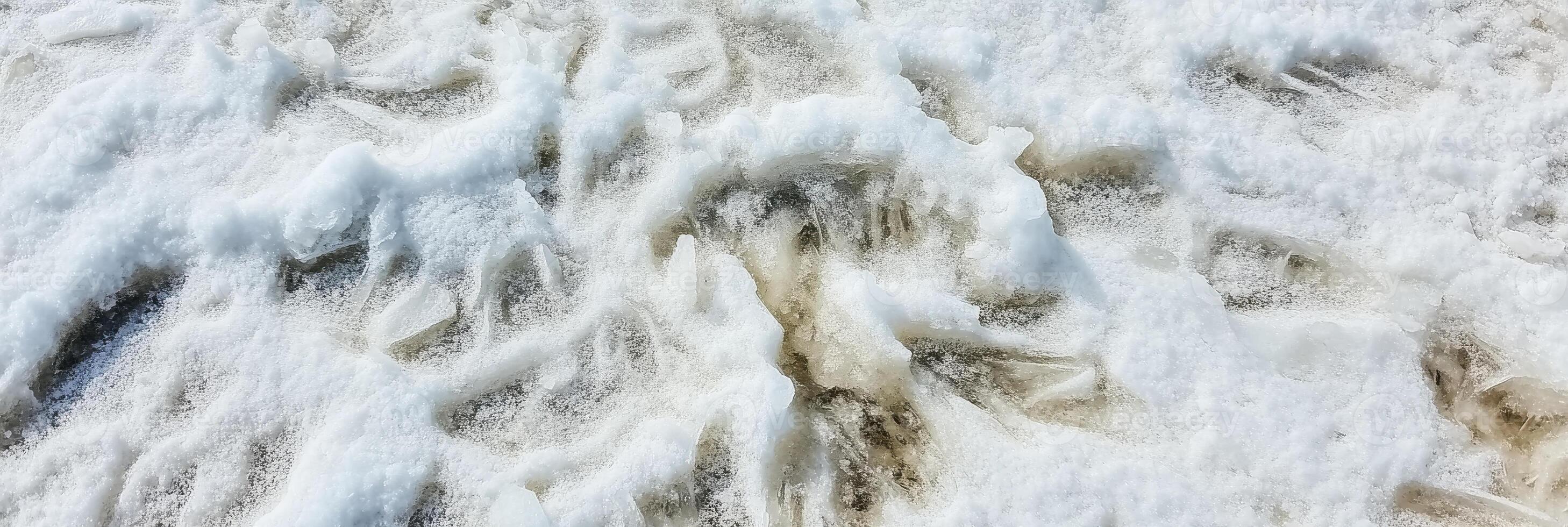 Close-up of frozen water formations on winter beach capturing natural texture photo