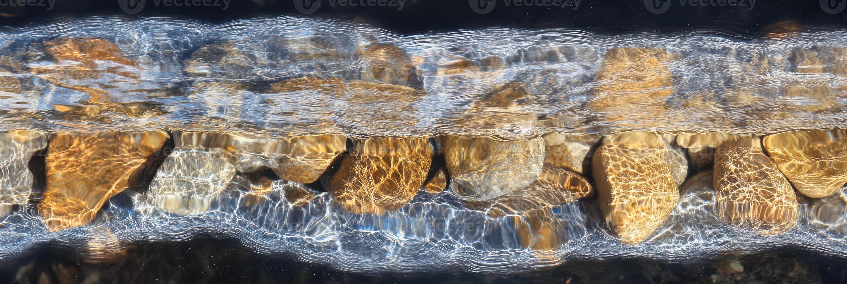 Tranquil stream with flowing water over colorful stones captured from above photo