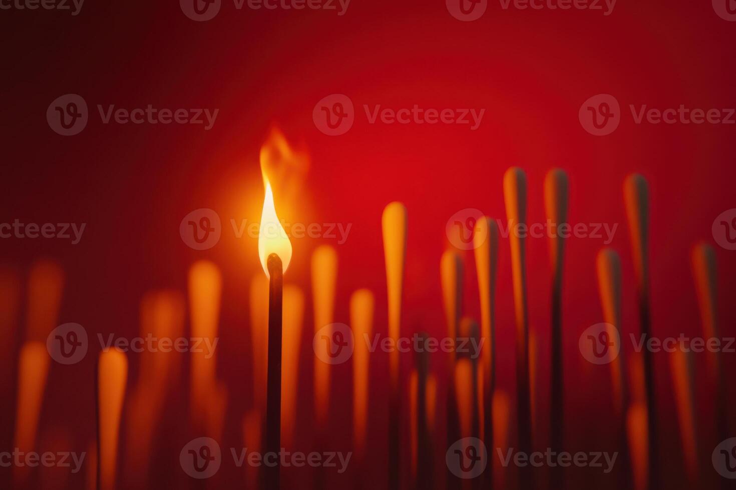 Glowing matchstick against red background illustrating ignition and heat in close-up photo