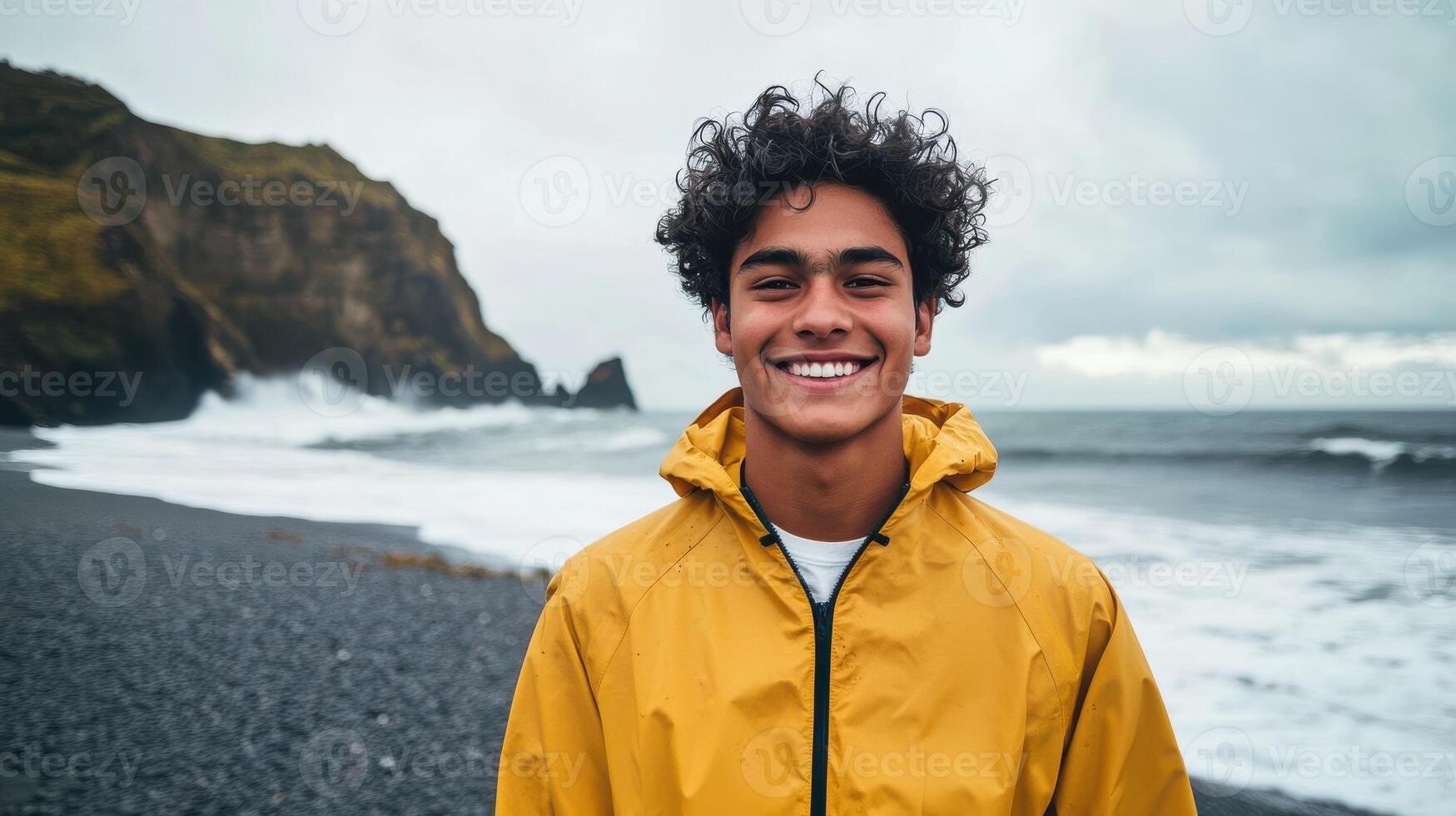 Young adventurer in jacket with backpack on rocky coast featuring ocean waves photo
