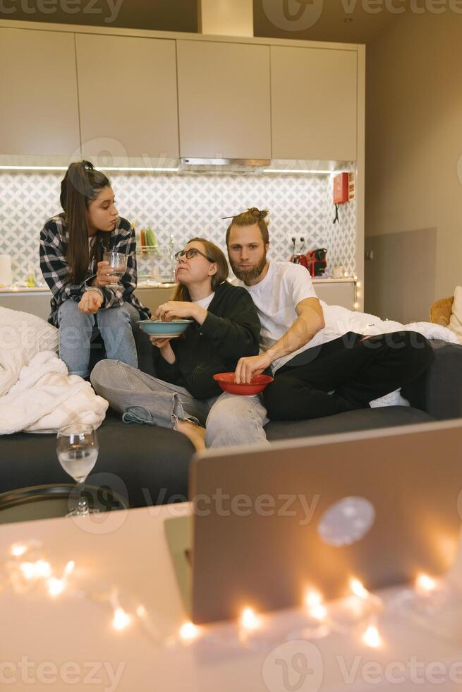 A group of friends enjoying a delightful and cozy movie night together in their home setting photo
