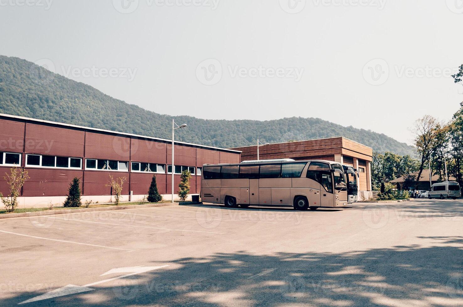 Large passenger buses stand in parking lot of bus station photo