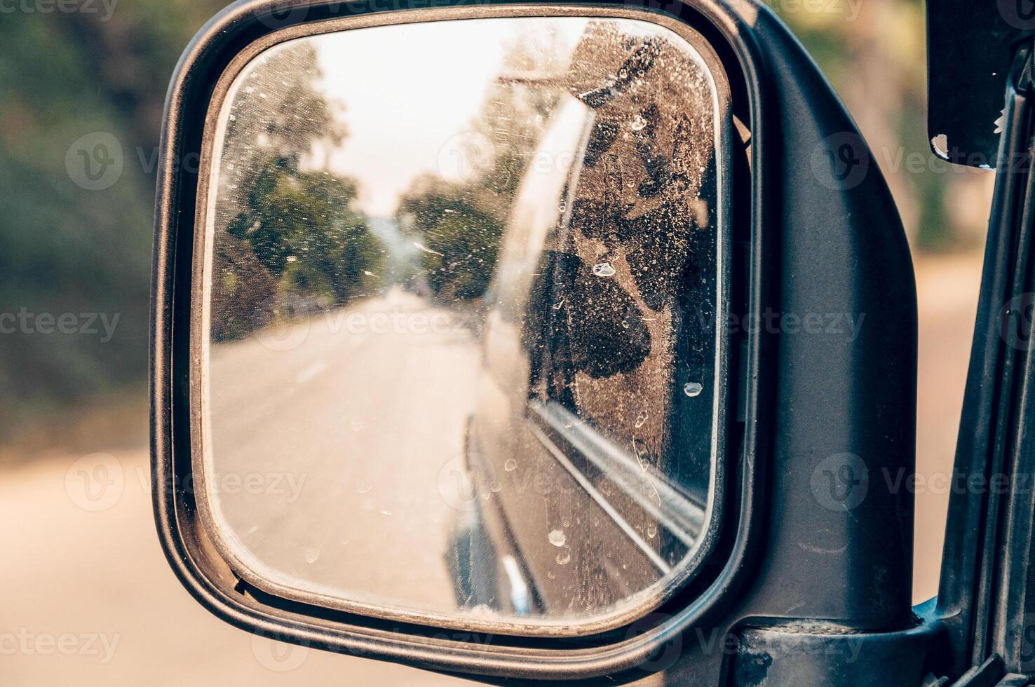Reflection of road from behind in side mirror of car photo