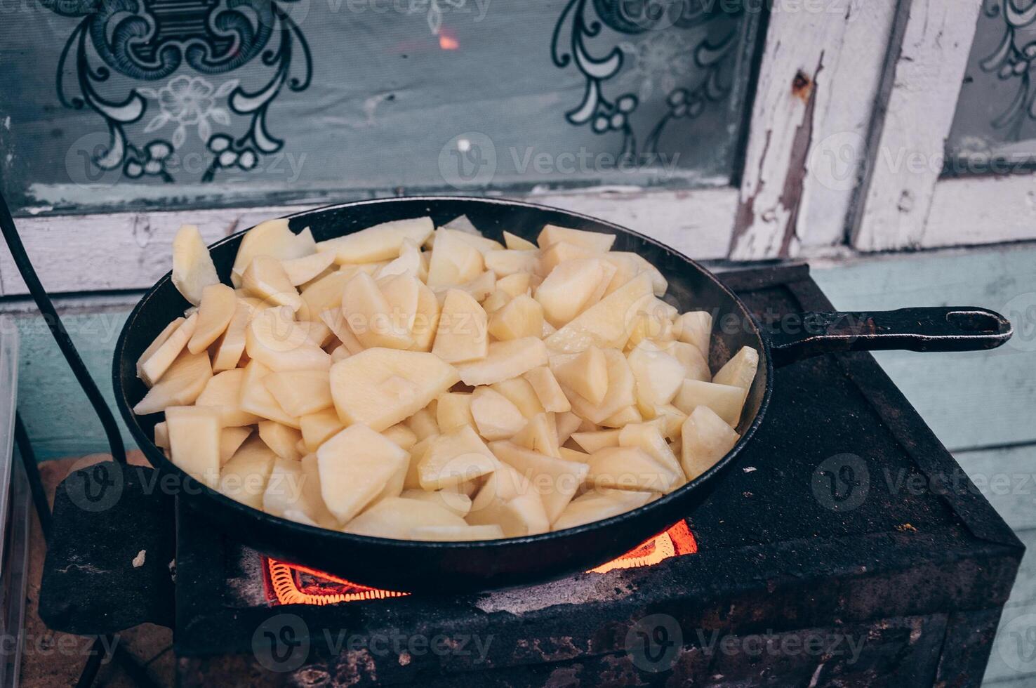 Potatoes fried frying pan, kitchen in poor refugee camp photo