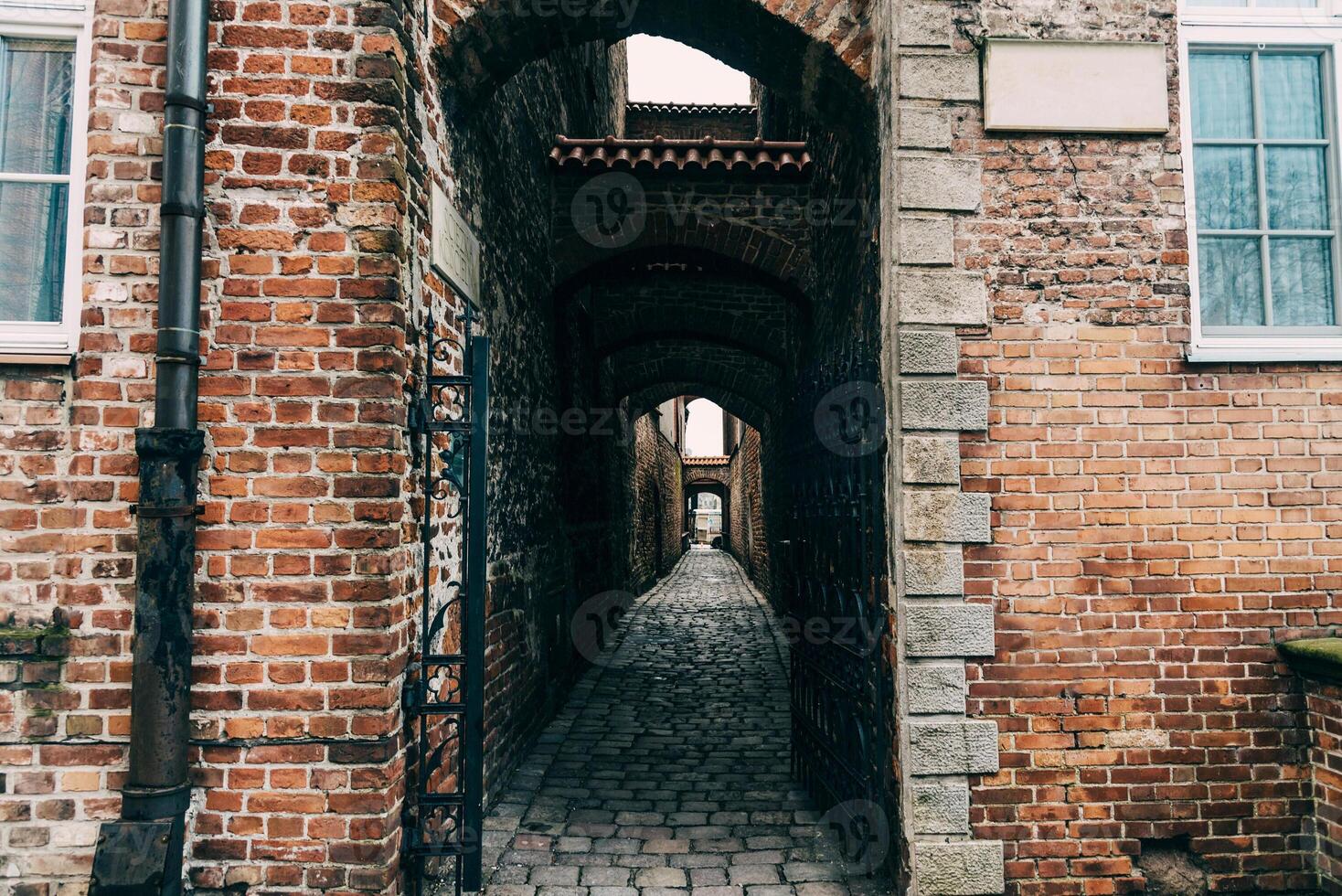 Passage arch corridor between streets inside brick residential building photo