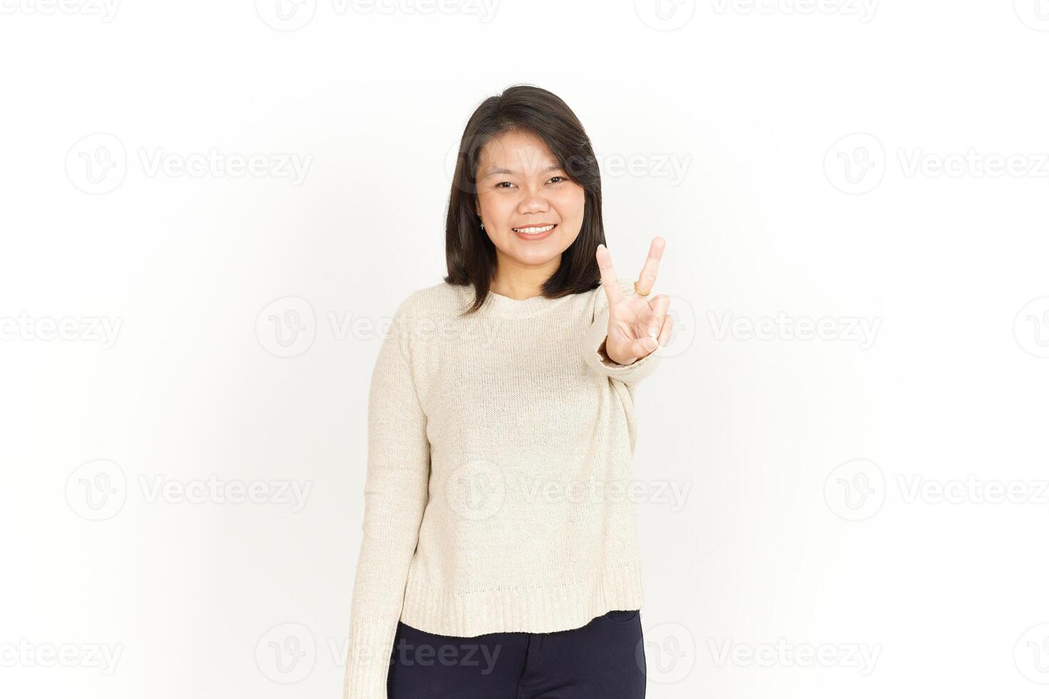 A woman in a sweater and pants is making a peace sign photo