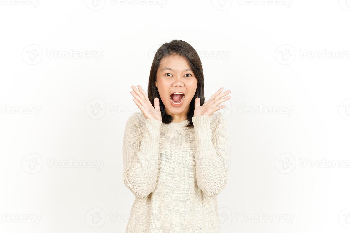 A woman is making a surprised face while standing in front of a white background photo