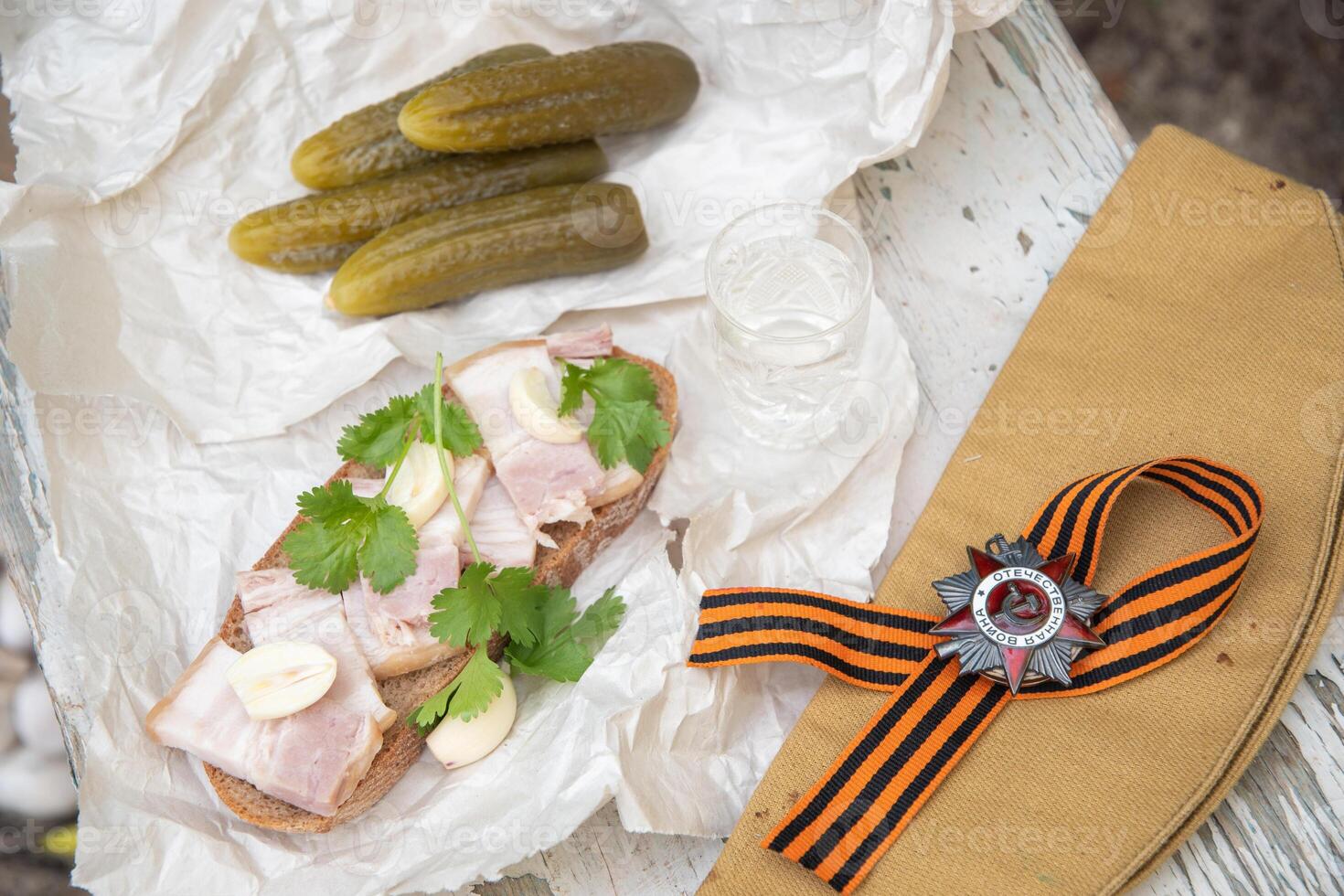 St. George's ribbon, the Order of the Great Patriotic War, May 9, Victory Day, and February 23, Defender of Fatherland Day, still life with a glass of vodka and a snack of lard and pickled cucumber, photo