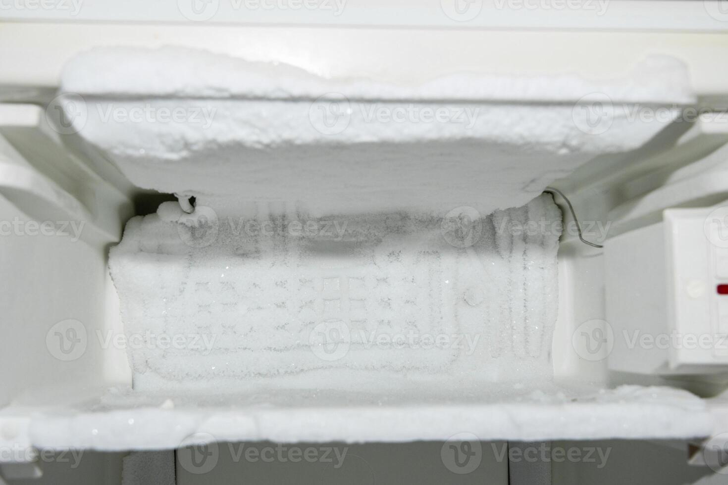 empty freezer compartment of the refrigerator, iced up on the walls with ice creeping out, defrosting required, photo