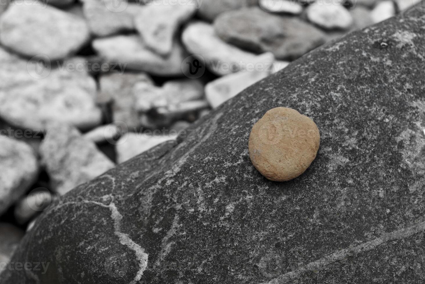 Minimalist Closeup of Single Pebble on Dark Stone in Natural Monochrome photo