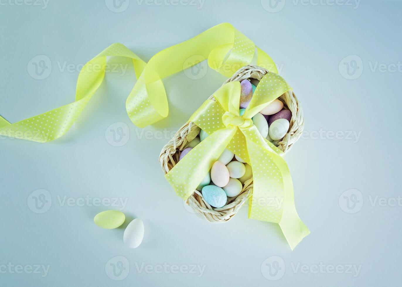 Composition of Easter eggs in basket with yellow ribbon photo