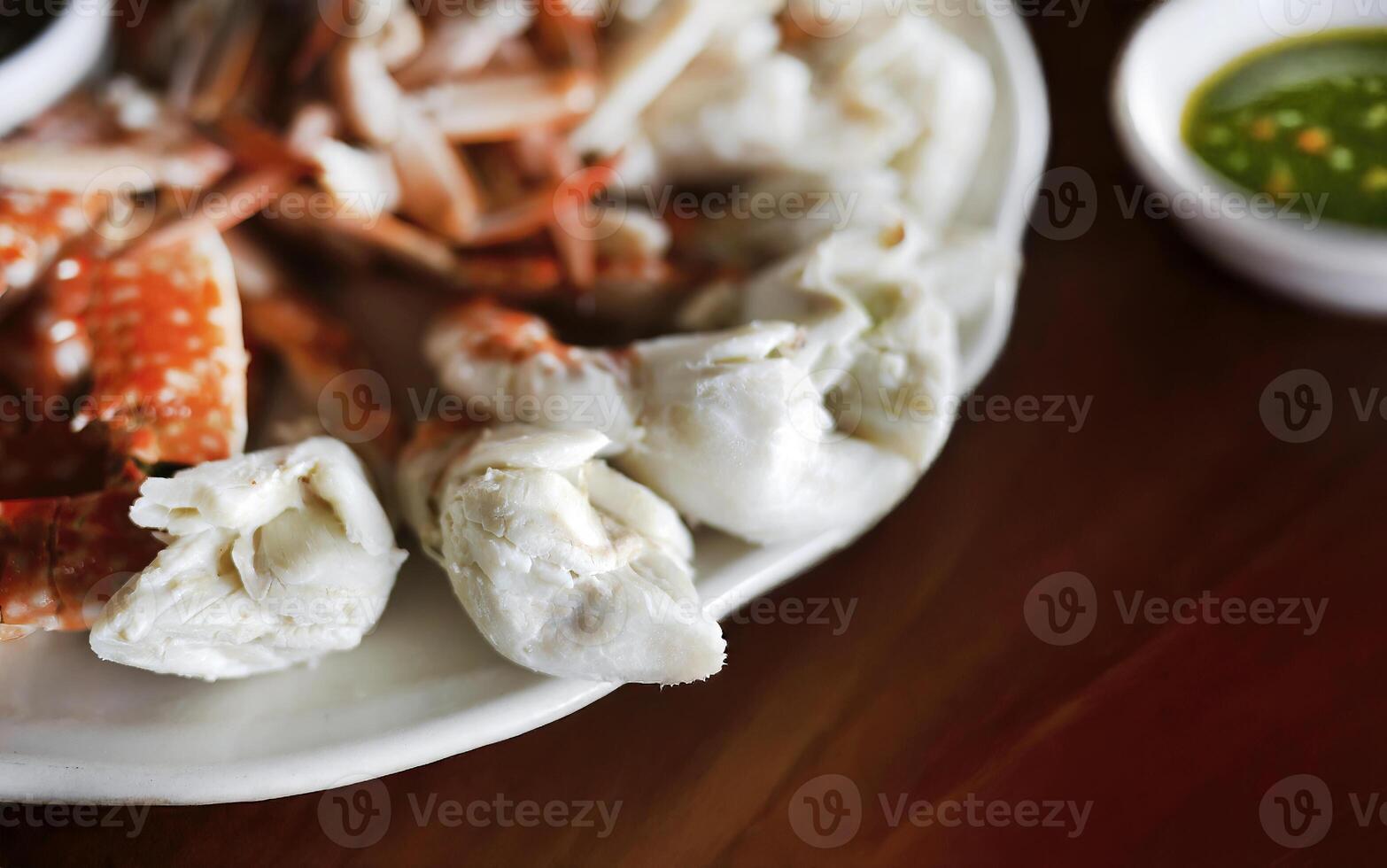 Steamed peeled blue swimming crab serving with Thai spicy chilli sauce, enjoying seafood meal from the sea, local restaurant, isolated photo