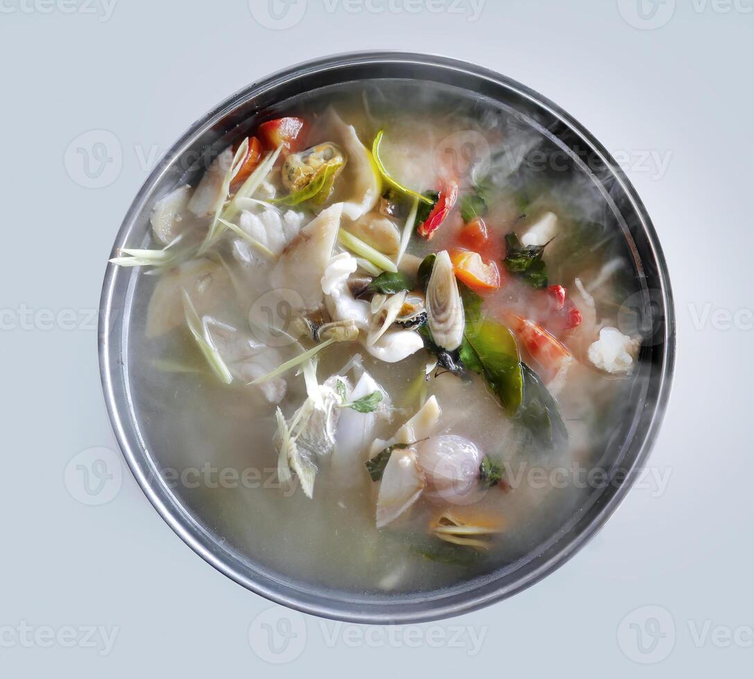 Hot Spicy and sour seafood soup served in steamer with smoke rising, top view directly above, seafood meal in Thai local restaurant photo