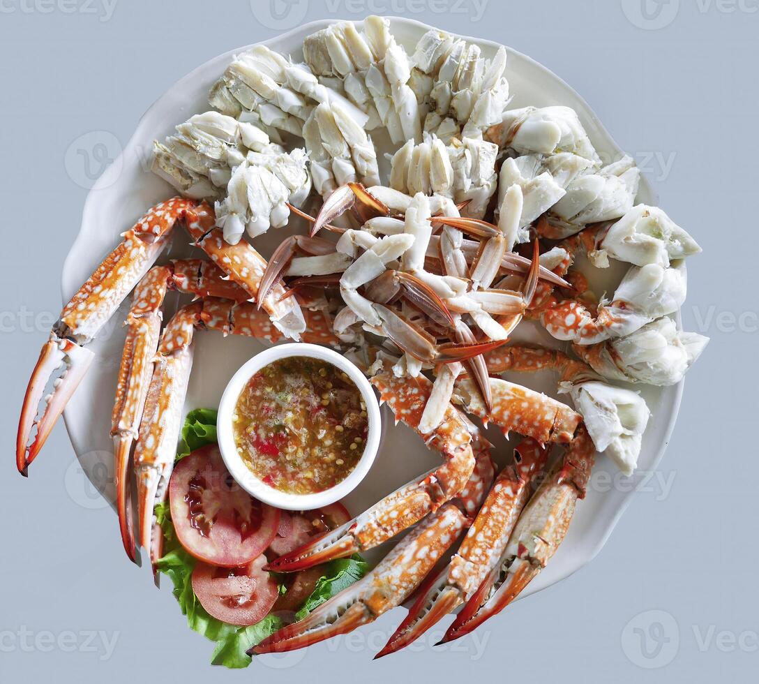 Steamed peeled blue swimming crab serving with Thai spicy chilli sauce, enjoying seafood meal from the sea, restaurant, isolated photo