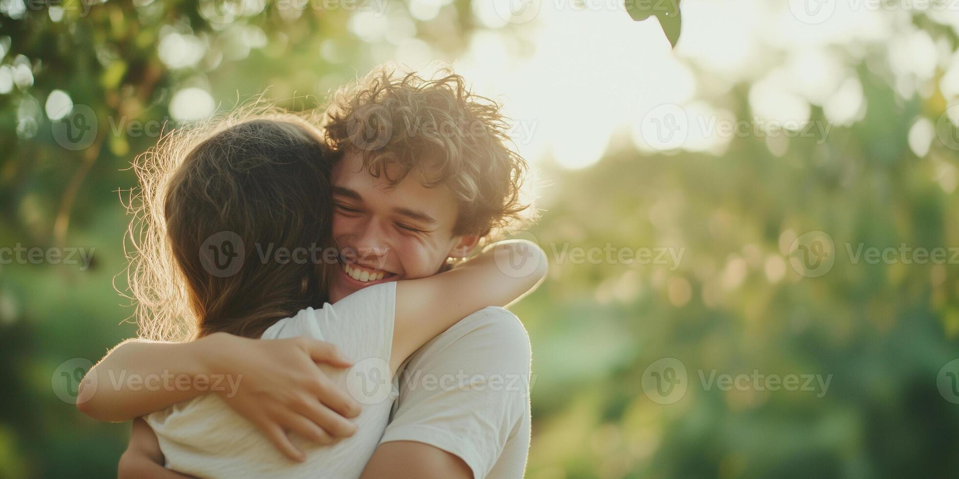 Young couple embracing in sunlit garden with joyful smiles and warm hugs photo