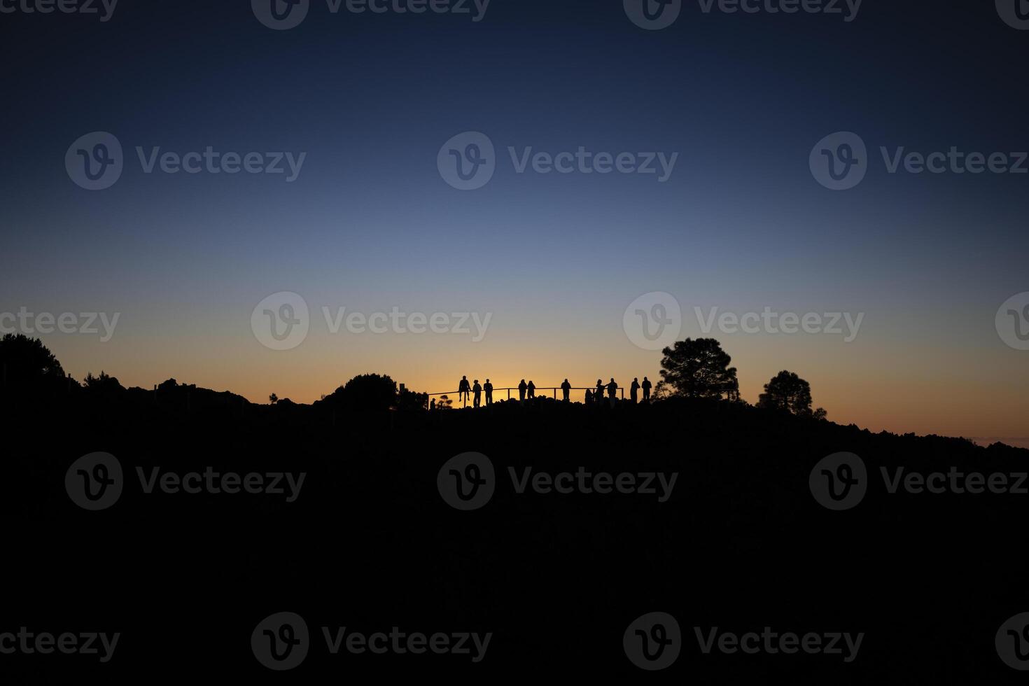 Silhouette of group of people watching the sunset on La Palma, part of Canary Islands of Spain, preparing for star gazing photo