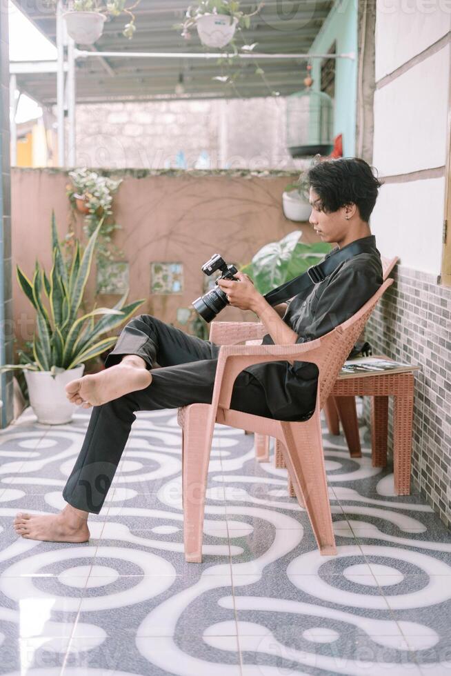 A Southeast Asian man checking the photo he just captured on his camera