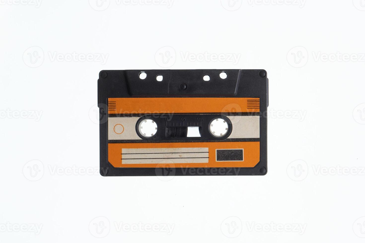 A vintage audio cassette tape with an orange and black label, isolated on a white background, evokes nostalgia and retro vibes. photo