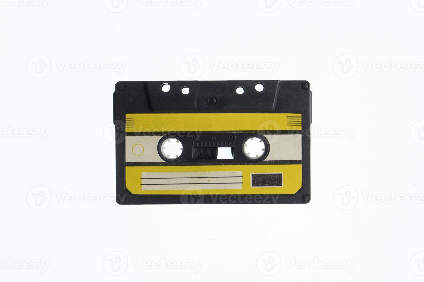 A vintage audio cassette tape with an yellow and black label, isolated on a white background, evokes nostalgia and retro vibes. photo