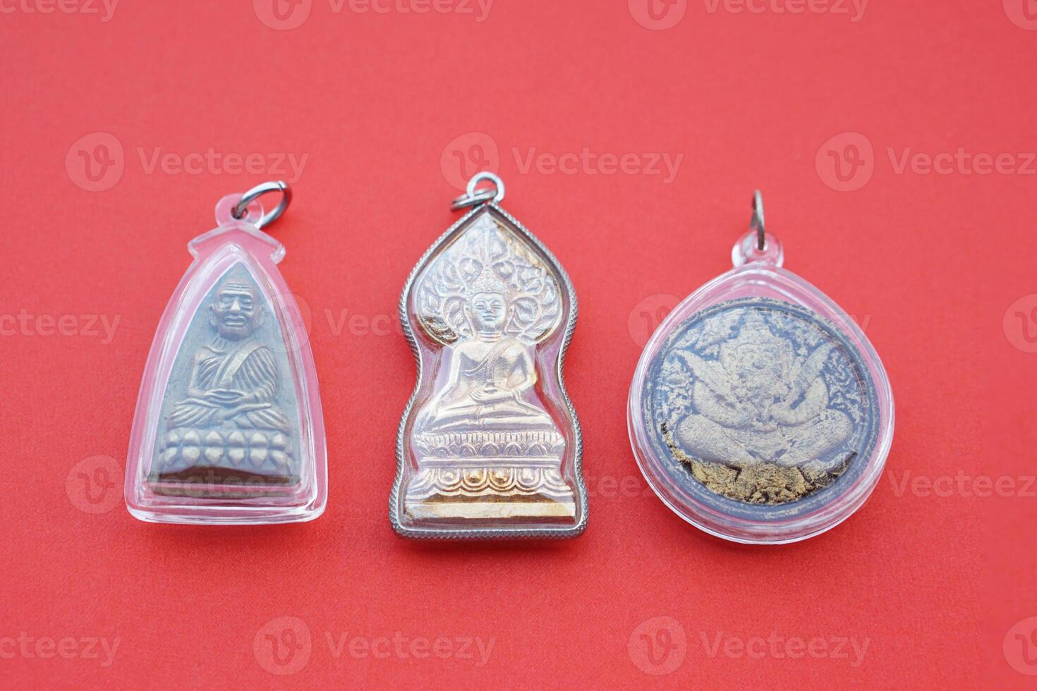 Buddha amulets on red background. Concept, faith and belief of Buddhist for holy to protect from danger, bring good luck, business prosperity and wealth. Collecting amulet as hobbies or exchange. photo